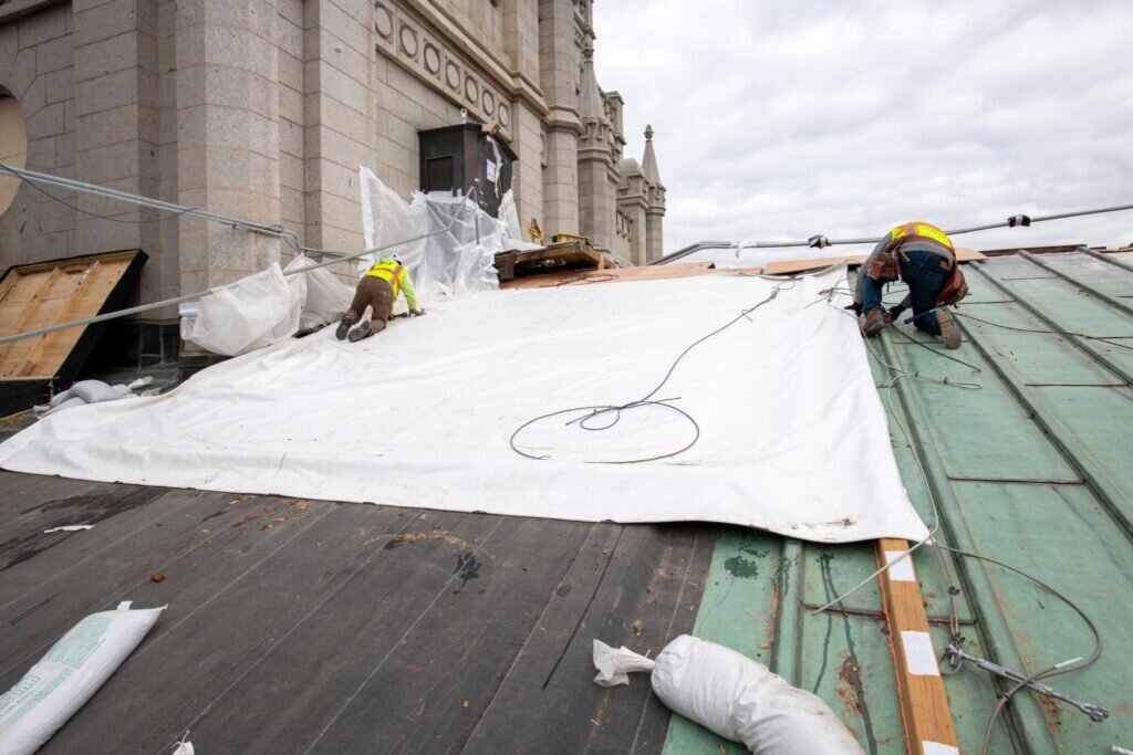 Workers install a temporary covering that is similar to a heavy-duty tarp in February 2021 in preparation for an upgraded roof as part of the Salt Lake Temple renovation project. Credit: The Church of Jesus Christ of Latter-day Saints